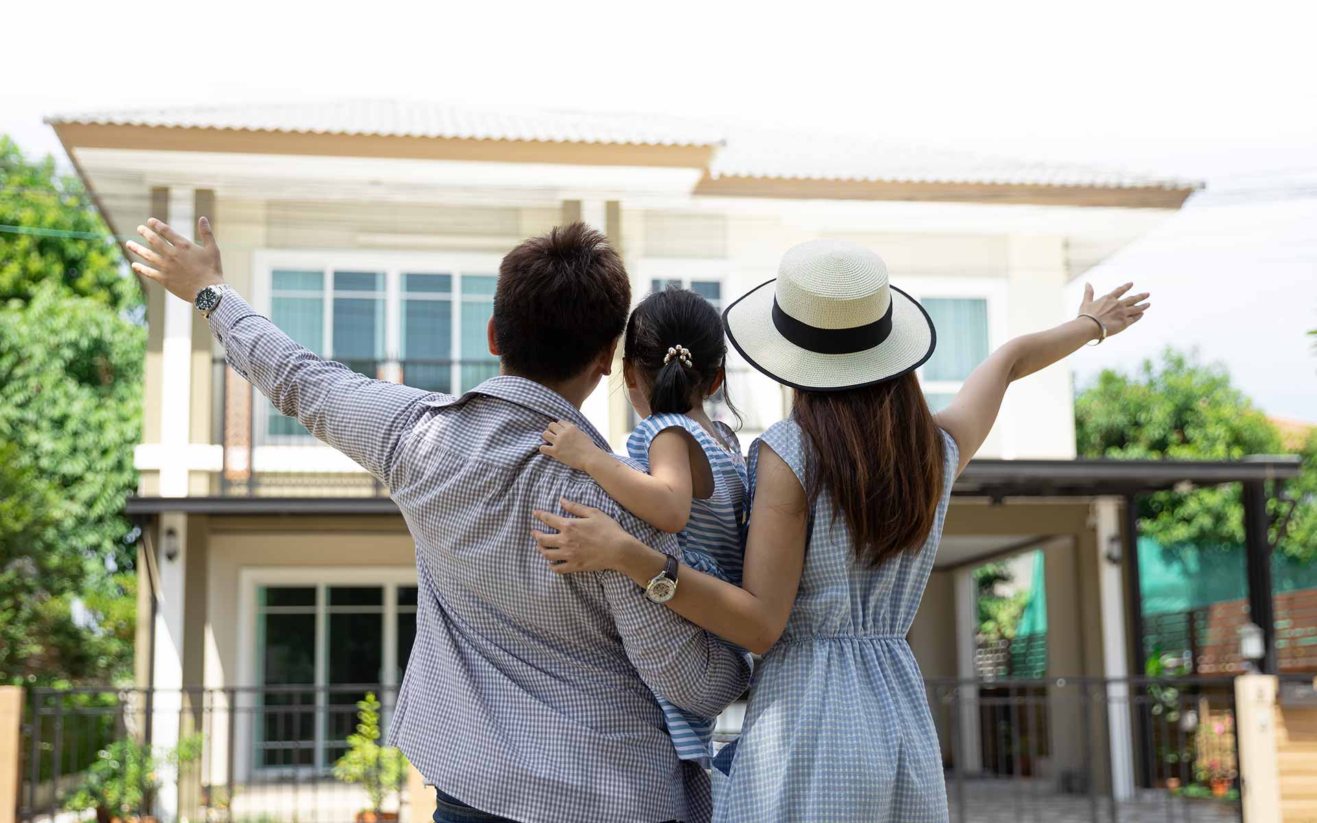Family standing in front on their new house